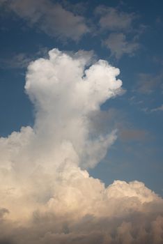 Low angle view of fluffy cumulus clouds against blue sky background. Beautiful sky background. Light blue sky with dramatic white and gray clouds. Perfect for sky replacement. High quality photo