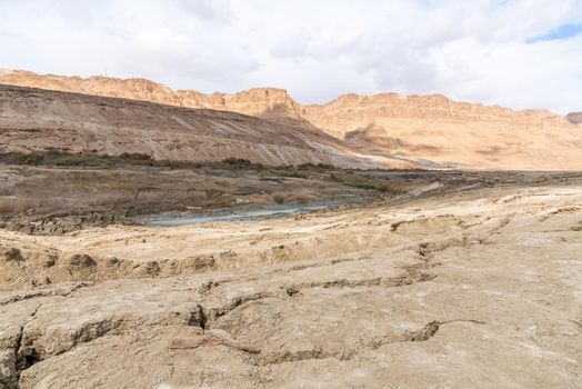 Sinkhole filled with turquoise water, near Dead Sea coastline. Hole formed when underground salt is dissolved by freshwater intrusion, due to continuing sea-level drop. . High quality photo