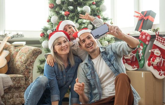 family having fun and playing together near Christmas tree indoors