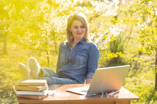 attractive young woman using laptop outside