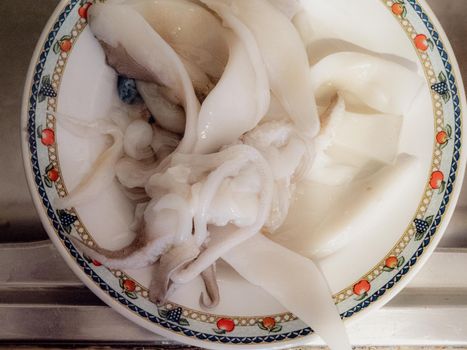 cleaning a raw adriatic cuttlefish at home in Numana, Marche, Italy
