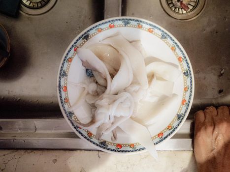 cleaning a raw adriatic cuttlefish at home in Numana, Marche, Italy