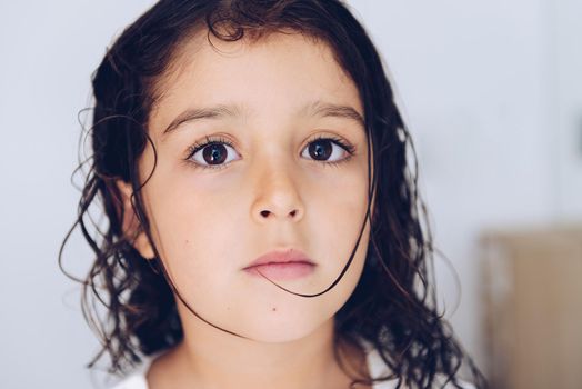 portrait of a serious little girl with wet hair after taking a bath, kids hygiene concept
