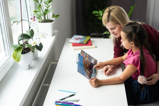 Cute little girl with therapist. Young woman teacher and child on private lesson