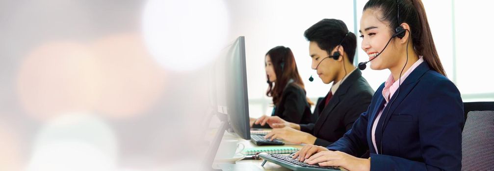 Business people wearing headset working in office in widen view to support remote customer or colleague. Call center, telemarketing, customer support agent provide service on telephone video call.