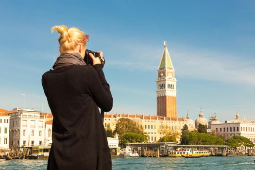 Female touris taking photo of San Marco Square over Grand canal in beautiful city of Venice, Italy.