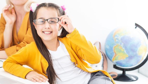 Private lesson. Attentive young woman tutor teacher help little girl pupil with studying math language correct mistakes explain learning material. Smiling mother assist small daughter with home task.