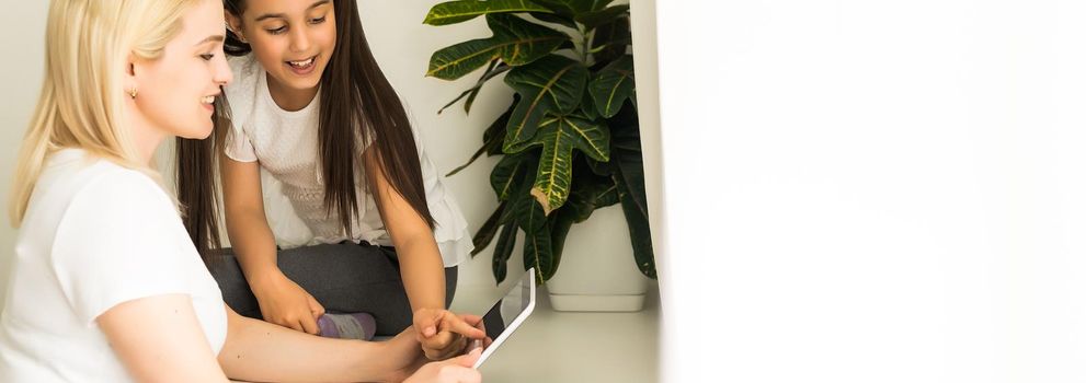 Online education of children. Mother and daughter of preschool watching a video lesson call chat at home