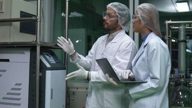Two scientist in professional uniform working in laboratory for chemical and biomedical experiment