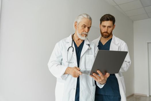 Two doctor colleagues discussing patient diagnosis stand in medicine clinic hall. High quality photo