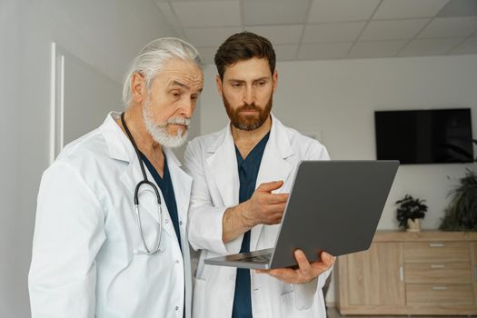 Two doctor colleagues discussing patient diagnosis stand in medicine clinic hall. High quality photo