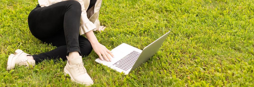 Young woman using laptop in the park.