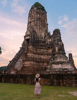 Ayutthaya, Thailand at Wat Chaiwatthanaram during sunset in Ayutthaya Thailand, Asian women with hat visiting a temple