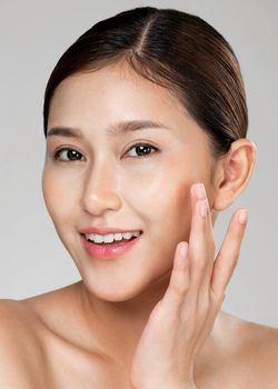 Closeup ardent young woman with healthy clear skin and soft makeup looking at camera and posing beauty gesture. Cosmetology skincare and beauty concept.