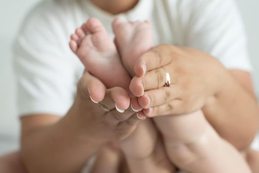 Parent holding in the hands feet of newborn baby.