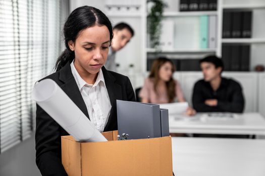 Depressed and disappointed employee packing her belongings after being fired for not being competent. Gossiped by her colleagues behind his back. Layoff due to economic depression.