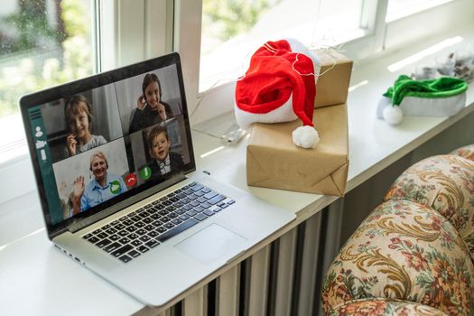 Virtual Christmas day house party. video conferencing, video call via computer in the home office. Online team gift opening conference calling