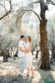 Man and woman hugging in an olive grove. High quality photo