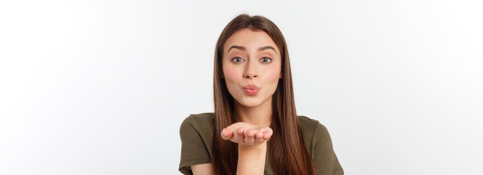 Portrait of a young woman blowing a kiss isolated over white