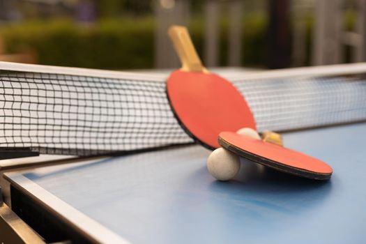 Ping pong table, rackets and balls in a sport hall.