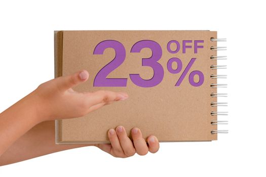 23 percent discount on isolate. Notepad from recycled paper in the hands of a child with text, sale up to 23 percent. The child is holding a notepad demonstrating a big sale