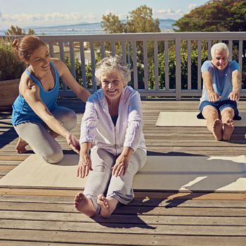 Fit and active in their golden years. a senior couple doing yoga together with an instructor on their patio outside