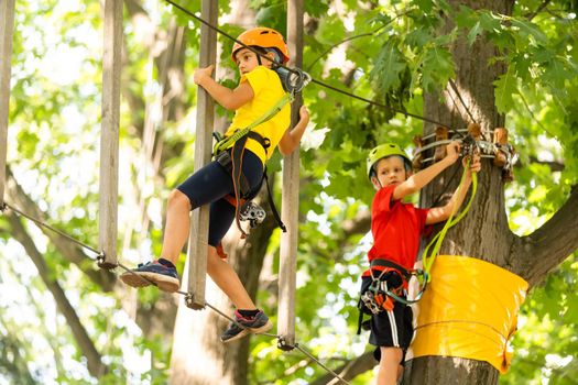 Cute children. Boy and girl climbing in a rope playground structure at adventure park.