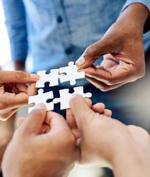Pulling together to solve a problem. a work group connecting pieces of a puzzle