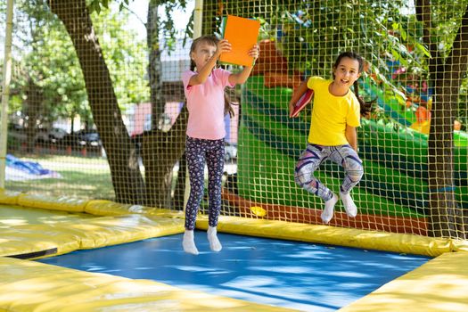 Happy children jumping on trampoline.