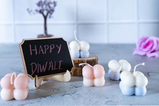 small bubble candles and blackboard with happy diwali written in chalk perfect card for diwali wishes in India