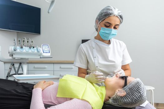 Dentist Examining Patient's Mouth with dental mirror In Clinic. Checkup concept