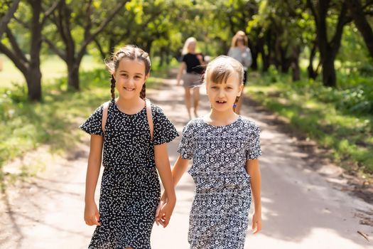Portrait of two girls with school bags after lesson in school.