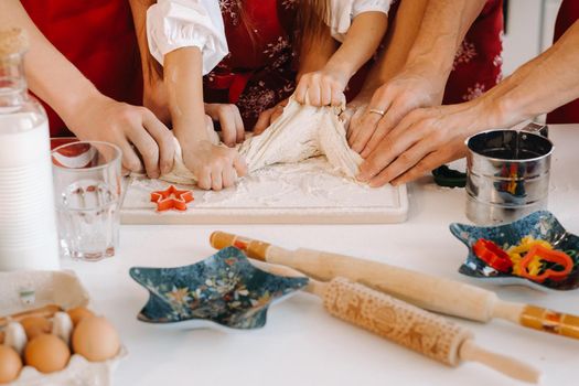 Close-up of hands cooking dough on the Christmas kitchen table.