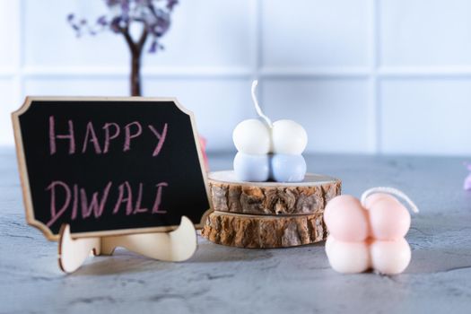 small bubble candles and blackboard with happy diwali written in chalk perfect card for diwali wishes in India