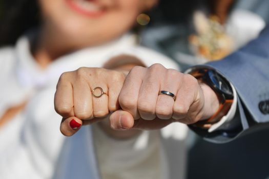 Newlyweds show wedding rings to the camera