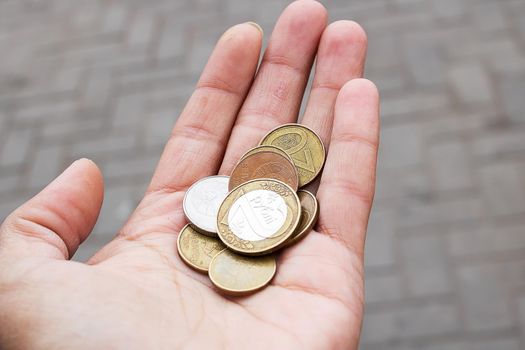 A pile of coins in the palm of hand close uo