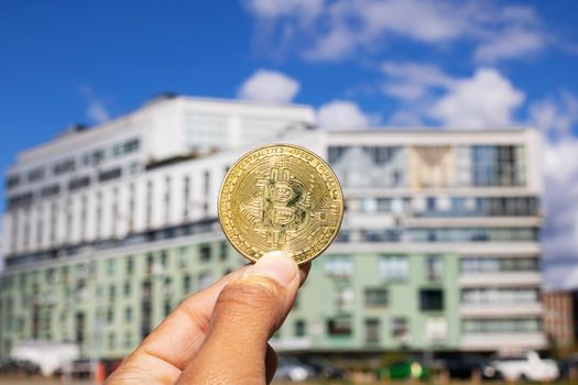 Bitcoin on the backdrop of a modern tall building