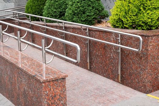 Wheelchair ramp and green bushes close up