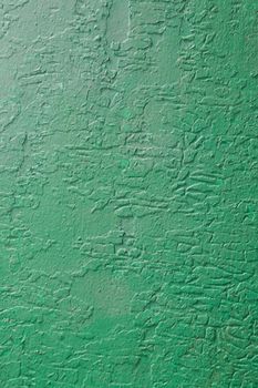 A surface of green cracked paint.Old paint damaged by the weather.