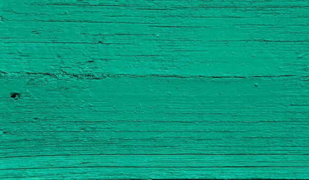 Vintage old green painted green wall background texture. The texture of an old time-damaged wooden board.