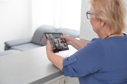 pretty senior woman using tablet computer at home.