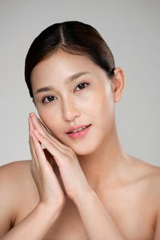 Closeup ardent young woman with healthy clear skin and soft makeup looking at camera and posing beauty gesture. Cosmetology skincare and beauty concept.