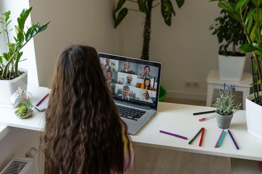 Online training. The teacher teaches the child a video call chat classroom video conferencing. Little girl teach a lesson using a laptop with sitting at a table at home.