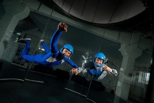 A man and a woman enjoy flying together in a wind tunnel. Free fall simulator.