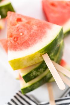 Slicing riped red watermelon to prepare chili lime watermelon pops.