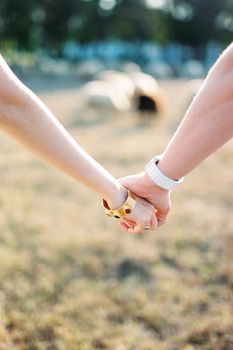 Man hand in a watch holds a woman hand in a bracelet. High quality photo