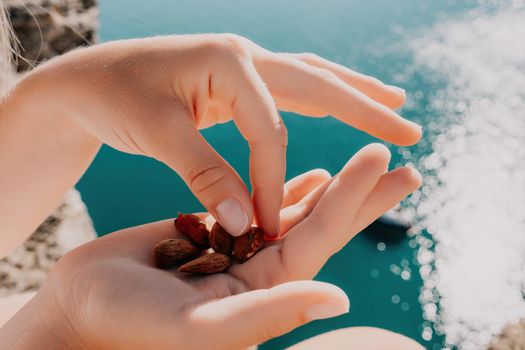 Unrecognizable caucasian woman eating young milky almond nuts. Healthy vegan food