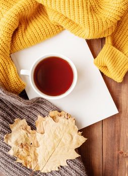 Hello fall. Cozy warm image. Cozy autumn composition, sweater weather. Pumpkins, hot black tea and sweaters