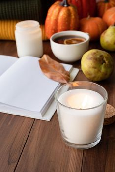 Hello fall. Cozy warm image. High angle view autumn composition with sweaters and candles, mockup design