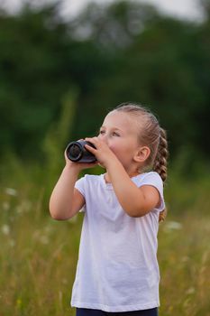 child drinking water from a bottle while outdoors